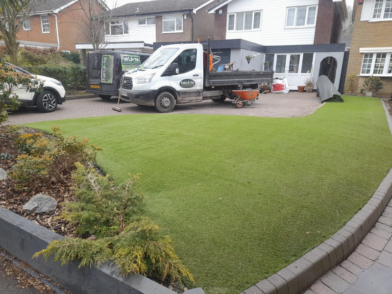fake grass, with Fairlawns artificial grass vans,and houses  in the background