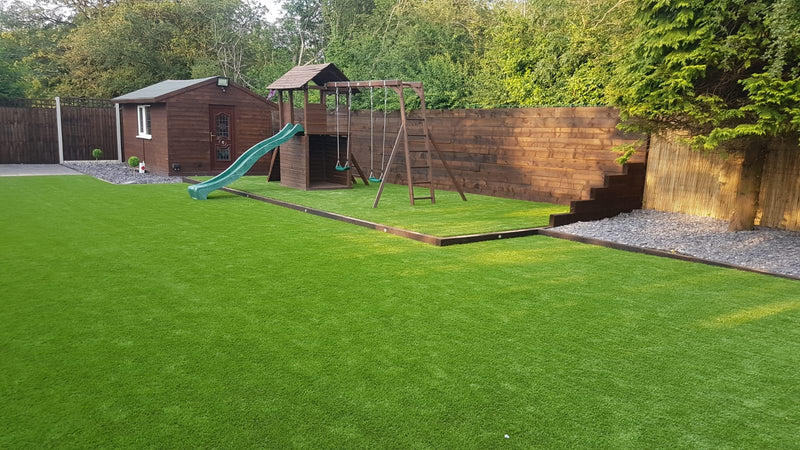 fake lawn wiith a small wooden step up to another grassed play area with play equipment