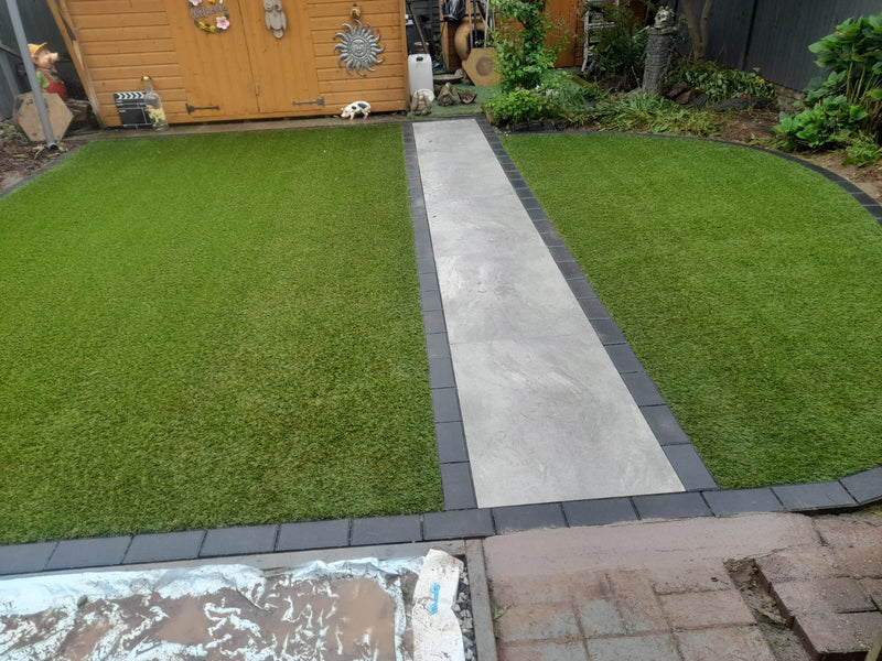 2 green lawns with porcelain slabs in the centre.
