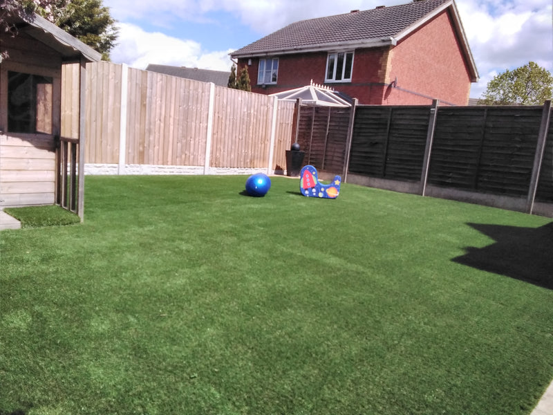 grass fences house in background